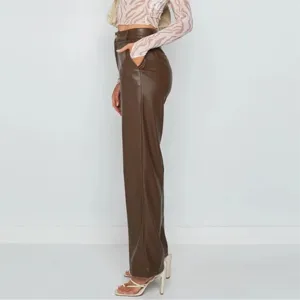 Detail view of women's brown PU leather pants featuring a high-waisted and straight-leg design.