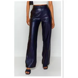 Detail view of women high waist shiny PU leather pants, straight leg fashion trousers.