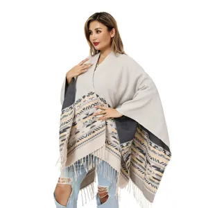 Bohemian knitted shawl poncho with reversible geometric patterns and tassel details