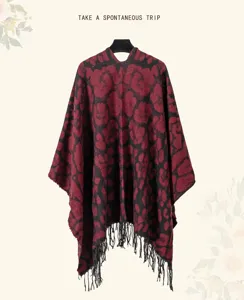 Close-up of a red and black leopard print knitted shawl poncho featuring long black tassels