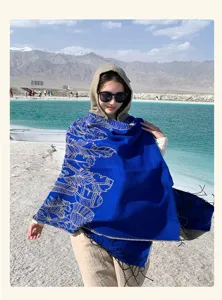 Detailed view of the vibrant blue ethnic style hooded shawl in a scenic desert.