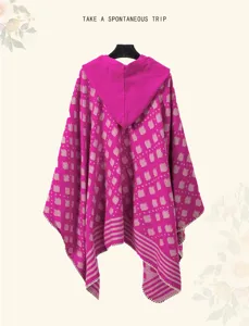 Detailed close-up of fuchsia knit hooded poncho with geometric ethnic patterns.
