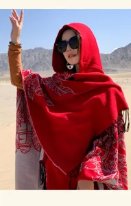 Outdoor detail of a red ethnic style hooded shawl wrap with tassels in the desert