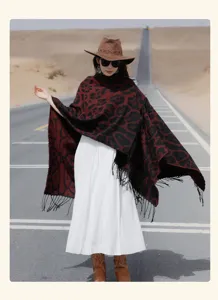 Model wearing a stylish red and black leopard print knitted shawl with fringe in the desert