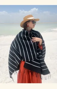 Close-up of a black and white striped ethnic style knitted shawl with tassel detail.
