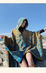 Detailed macro view of women's hooded star pattern knitted poncho cape with fringe edge