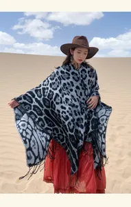 Detailed macro view of a grey leopard print knit shawl with elegant tassels in desert.