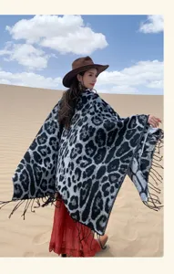 Asian model in leopard print tassel knit poncho standing in a scenic desert landscape.