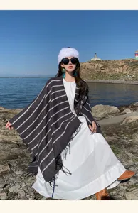 Asian model wearing an ethnic striped knitted shawl with tassels for travel outfit