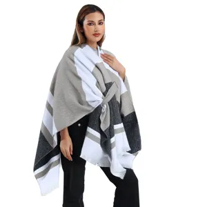 Modella indossa una mantella jacquard a righe con fiocco laterale e frange