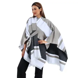 Vista dettagliata di un elegante poncho in maglia a righe con cintura laterale e frange