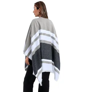 Vista posteriore di un elegante poncho in maglia a righe con frange per autunno e inverno