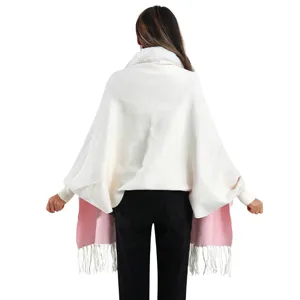 Detaillierte Rückansicht des weißen Strickponchos mit rosa Futter und Pelzkragen