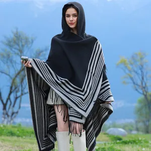 Cozy hooded knitted shawl with elegant grey stripes and fringe detail in outdoor setting