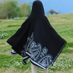 Rückansicht Damen Strickponcho mit Kapuze und weißem Paisley-Blumenmuster in Schwarz