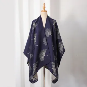 Detailansicht des dunkelblauen Ponchos mit eleganten weißen Ginkgoblatt-Jacquard-Mustern