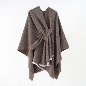 Detailed close-up of a brown knitted poncho with a stylish diagonal tie-up design
