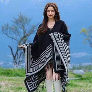 Detailed view of women's thick warm knit shawl featuring grey stripes and tassel fringe