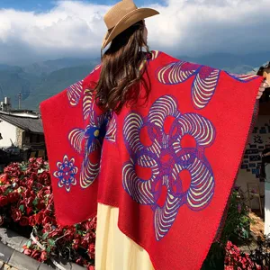 Rückansicht eines roten Strickschals mit lebhaften Blumenmustern in der Natur.