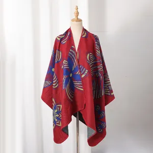 Roter Strick-Poncho-Schal mit blauem Schmetterlingsmuster auf einer Schaufensterpuppe