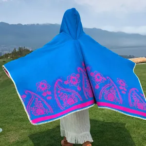 Rückansicht eines leuchtend blauen Strickponchos mit Kapuze und Paisley-Muster