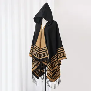 Elegant cozy hooded knitted poncho with striped pattern and fringe detail on mannequin