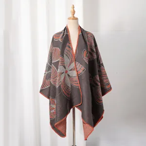Detailansicht eines Damen-Strickponchos mit geometrischen Blumenmustern auf einer Schaufensterpuppe