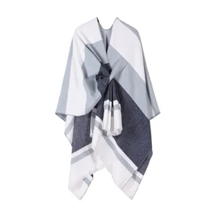 Vista dettagliata di un caldo poncho a righe blu navy e grigio con design a fiocco