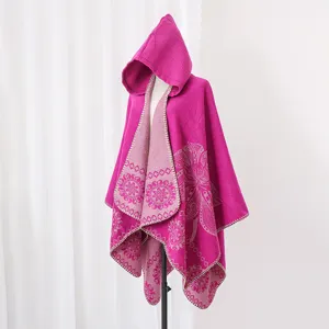 Nahaufnahme eines fuchsiafarbenen Kapuzenponchos mit floralem Jacquard-Muster auf Puppe