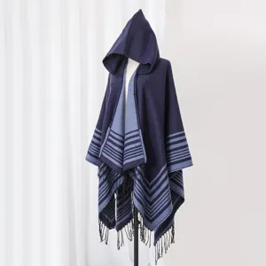 Side view of a hooded knit poncho with navy blue stripes and fringe detailing.