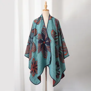 Detail eines gestrickten Damen-Ponchos mit abstrakten blau-orangen geometrischen Mustern.