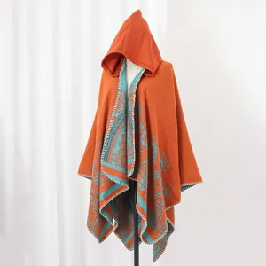Detailansicht eines orange-blauen Strick-Ponchos mit Kapuze und Boho-Muster für Damen.