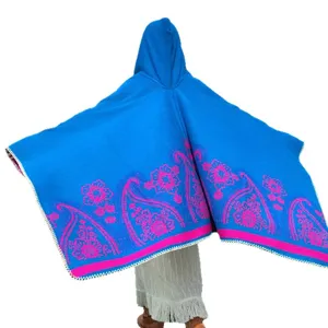 Bohemian blauer Strickponcho mit Kapuze, rosa Paisleymuster und dekorativen weißen Ziernähten