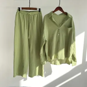 Details of the green cotton linen two piece set featuring a loose shirt and wide leg trousers.