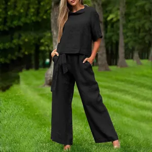 Casual black two-piece outfit detail, featuring short sleeve top and wide leg trousers.