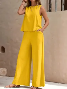 Vue détaillée du haut sans manches jaune et du pantalon ample en décor extérieur.