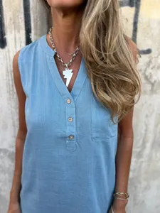 Close-up detail of casual sleeveless light blue linen dress with V-neck and wooden buttons.