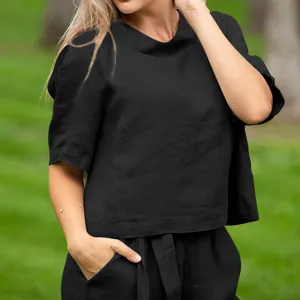 Close-up detail of casual black short sleeve top and matching pants, summer style fashion outfit.