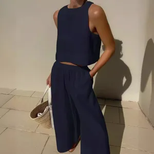 Ensemble deux pièces élégant bleu marine haut court sans manches et pantalon ample.