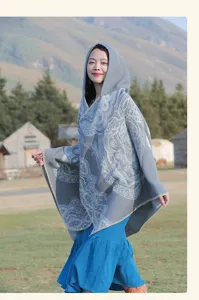 Detailansicht des grauen Ethno-Ponchos mit Paisley-Muster und Kapuze für Reisen.