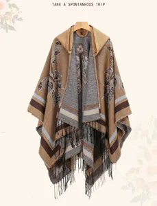 Detailansicht eines ethnischen Kapuzenponchos mit floralen Mustern und langen schwarzen Fransen.