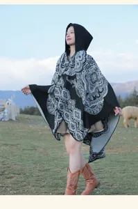 Nahaufnahme eines böhmischen Strick-Kapuzenponchos mit Ethno-Print auf einer Wiese