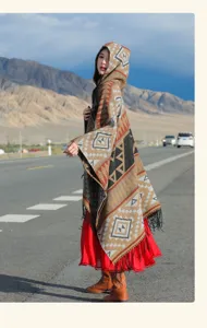 Boho-Strickschal mit Kapuze und geometrischen Mustern auf einer malerischen Straße