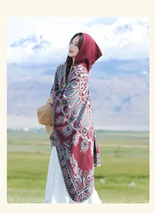 Nahaufnahme eines burgunderfarbenen Strickschals mit Kapuze und Paisley-Muster für Reisen
