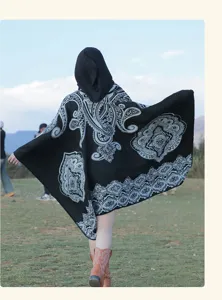 Rückansicht eines schwarzen Poncho-Schals mit Paisleymuster in einer Graslandschaft