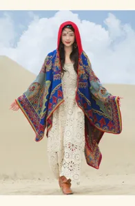 Scialle bohémien in maglia con cappuccio e motivi floreali vivaci in un deserto