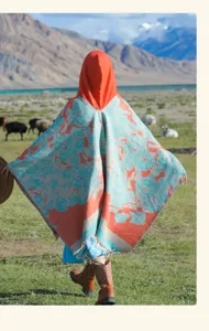 Vue arrière d'un poncho en tricot à capuche avec motifs floraux et franges