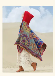 Vista dettagliata di una donna con un colorato poncho etnico in maglia con cappuccio nel deserto