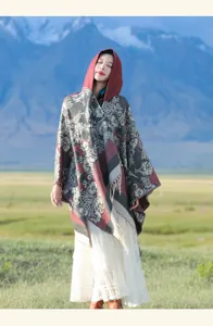 Modèle portant une cape châle en tricot à fleurs sur fond de montagne enneigée