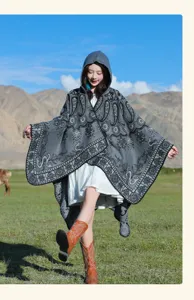 Outdoor-Lifestyle-Foto eines grauen gestrickten Kapuzen-Ponchos mit Paisley-Mustern.